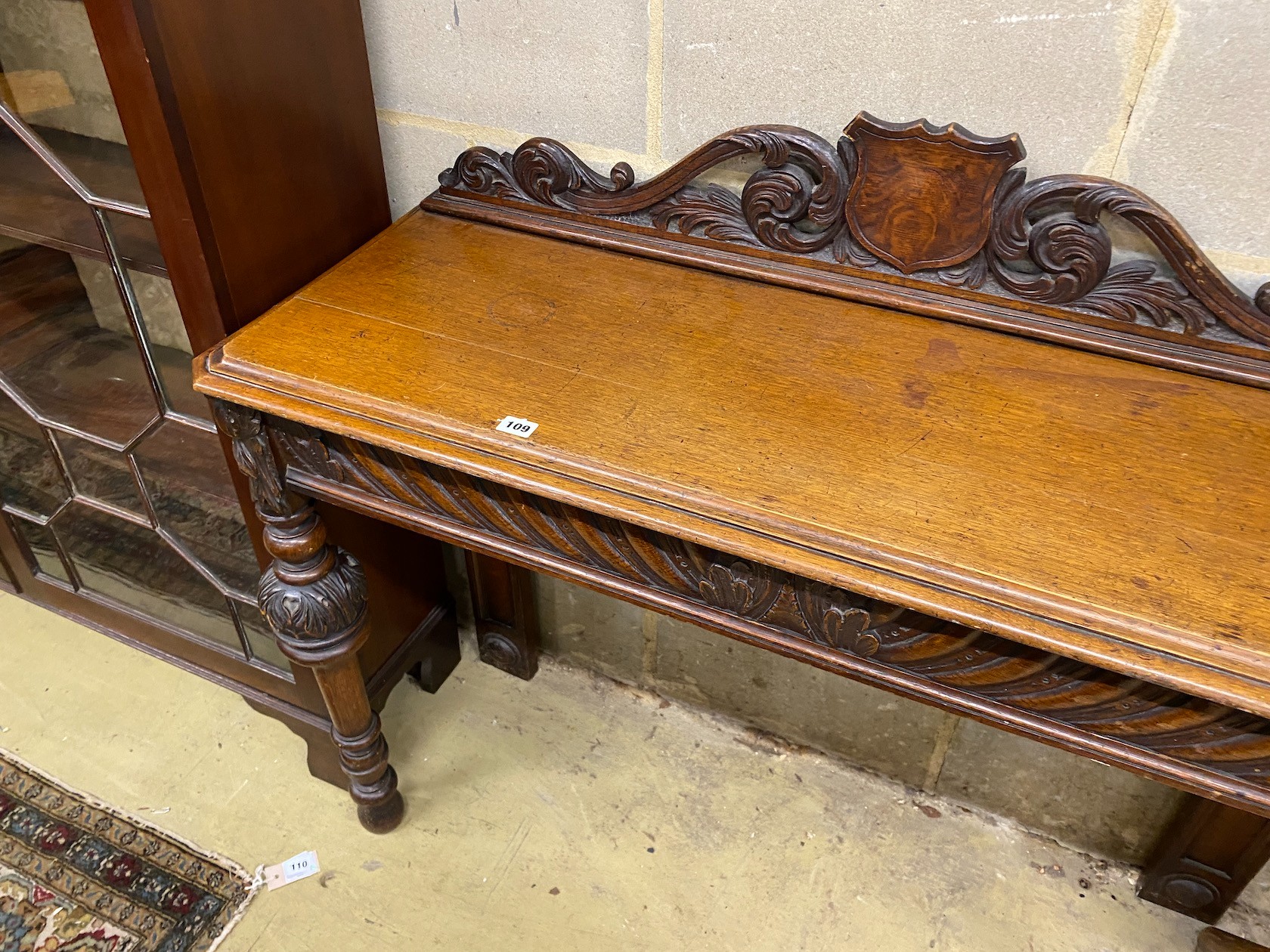 A Victorian oak console table, vacant shield cartouche and scrolling acanthus surmount to back, width 120cm, depth 42cm, height 102cm
